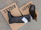 a pair of black boots sitting on top of a cardboard box