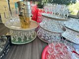 many glasses on a table with plates and cups on it