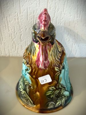 une figurine représentant un coq, à laquelle est attachée une étiquette