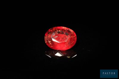 a close up of a red diamond on a black surface