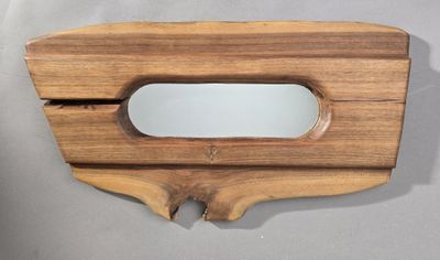 un miroir en bois muni d'une poignée en bois, posé sur une table