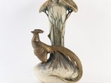 a vase with a bird on it sitting on a table