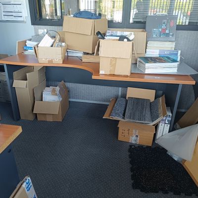 un bureau sur lequel sont posées de nombreuses boîtes