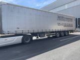 un camion qui roule dans la rue devant un immeuble