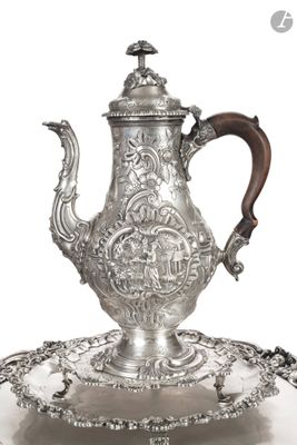 une théière ancienne en argent posée sur un plateau muni d'une poignée en bois