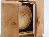 a small clock inside of a small box on a white surface
