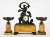 une horloge posée sur une table, à côté de deux vases
