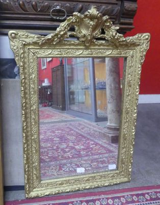 a gold picture frame sitting on the floor next to a red wall