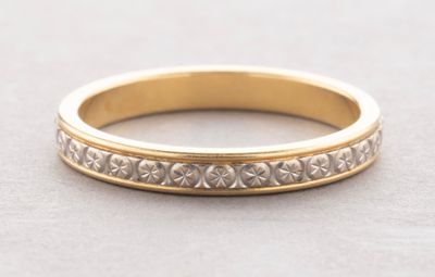a close up of a gold wedding ring on a gray surface