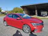 a red car parked in front of a building with a person taking a picture