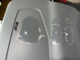 two holes in the hood of a car with a sticker on it