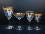 four wine glasses are lined up on a black surface