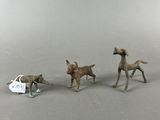 three figurines of dogs and a car on a table
