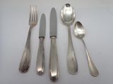 five silver spoons and two silver spoons on a table