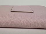 a pink purse sitting on top of a white table