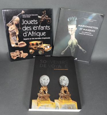 trois livres posés sur une table, à côté d'une statue représentant une femme et d'une autre représentant un homme