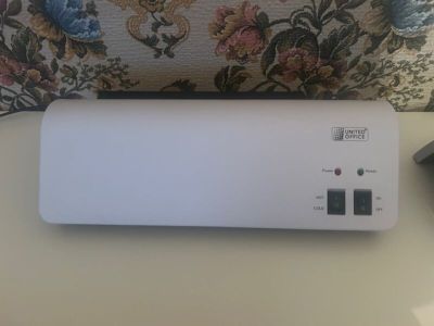a white air purifier sitting on a table next to a pillow