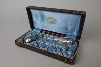 une cuillère en argent et une cuillère dans une boîte posée sur une table