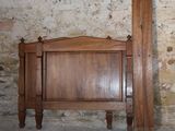 a bed with a wooden headboard next to a brick wall