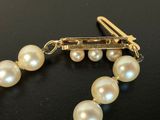 pearl bracelet with a gold clasp on a black surface
