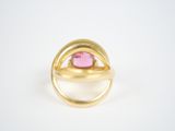a close up of a gold ring with a pink stone in it