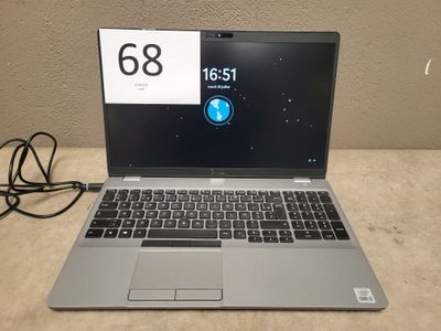 un ordinateur portable ouvert posé sur une table à côté d'un chargeur