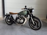 a green motorcycle parked in a garage next to a garage door
