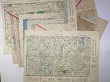 many maps on the wall of a room