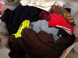 a pile of clothes in a basket on a bed