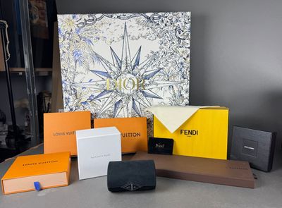 un assortiment de portefeuilles Louis Vuitton et d'autres articles posés sur une table