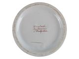 a white plate with red writing on it on a white surface