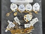 a bag of gold and silver necklaces with tags on them