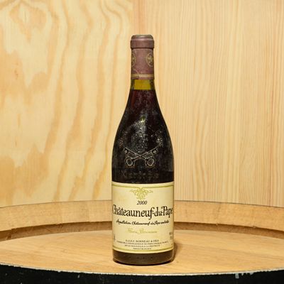 a bottle of wine sitting on top of a barrel
