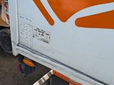 an orange and white truck that is parked in a lot