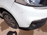 a small white car parked on the side of the road