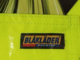 the back of a yellow jacket with a black label on it