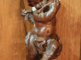 a statue of a baby sitting on a wooden wall
