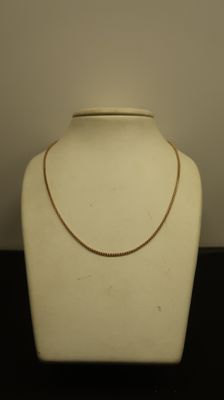 Le collier est présenté sur un mannequin devant un fond blanc.