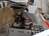 a machine that is cutting a piece of wood on a table