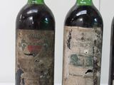 three bottles of wine are lined up on a white surface