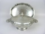 an antique silver plate with a lid on a white background