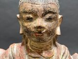 an image of a statue of a person sitting on a table