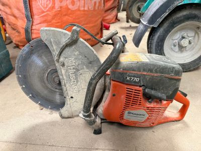 une tronçonneuse posée par terre à côté d'un sac
