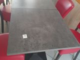 une longue table avec des chaises rouges au milieu de la pièce