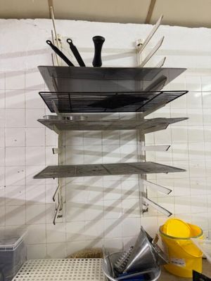une étagère avec des casseroles et des poêles dans une cuisine