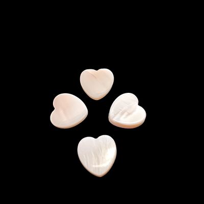 three white heart shaped shells on a black background