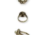 trois bagues et une bague ornée de perles sur fond blanc