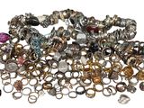 a pile of rings and other jewelry on a white surface