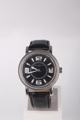 une photo d'une montre noire posée sur un socle blanc