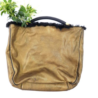 a small plant in a brown bag with a black handle